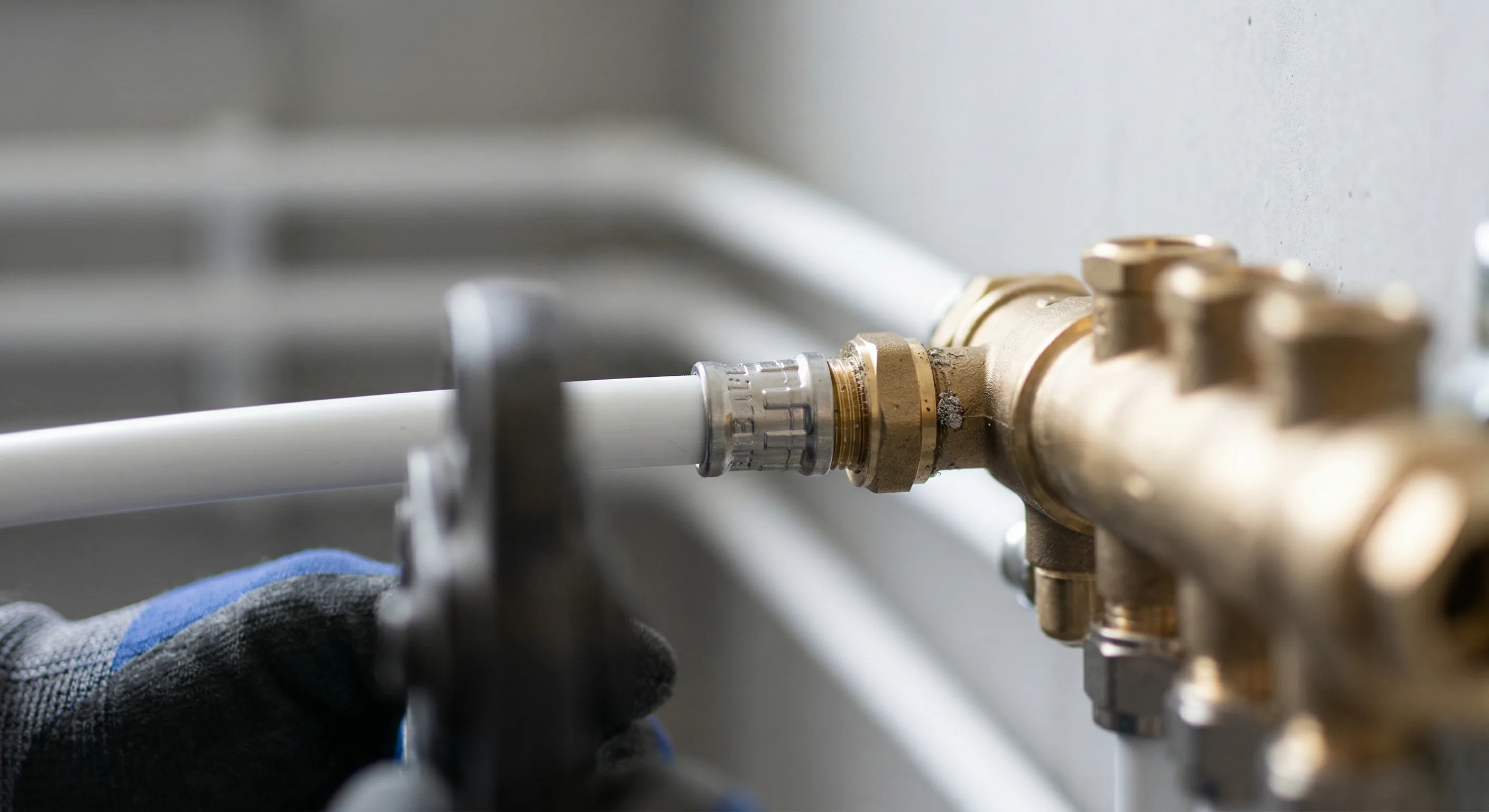 Trinkwasser-Installation – Topallaj Haustechnik GmbH Klempner verbindet Trinkwasserrohre mit Messingverteiler – Topallaj Haustechnik