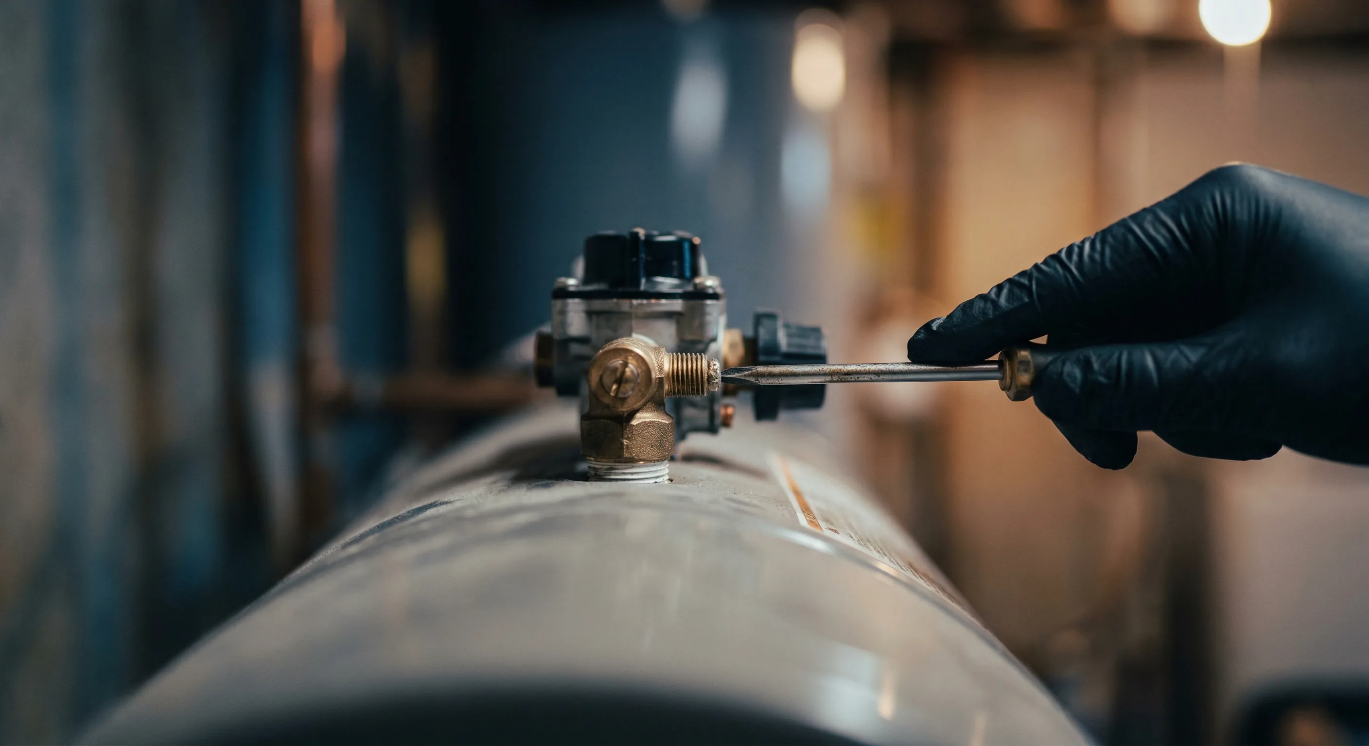 Warmwasserbereiter Service – Topallaj Haustechnik GmbH Techniker wartet großen Warmwasserspeicher mit Druckventil – Topallaj Haustechnik